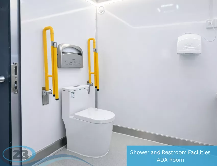 Restroom trailer interior with a toilet and yellow grab rails